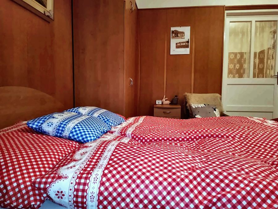 Manželská postel s červeným kostkovaným povlečením